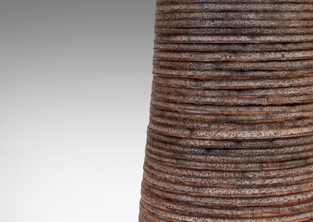 Gallery BAC flared cylindrical form with ridged texture and brushed articulated foot, glazed in matte dark brown