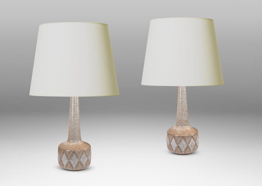 Gallery BAC drum form with carved harlequin design, and tall conical neck, glazed in warm pale gray with some diamond motifs in white