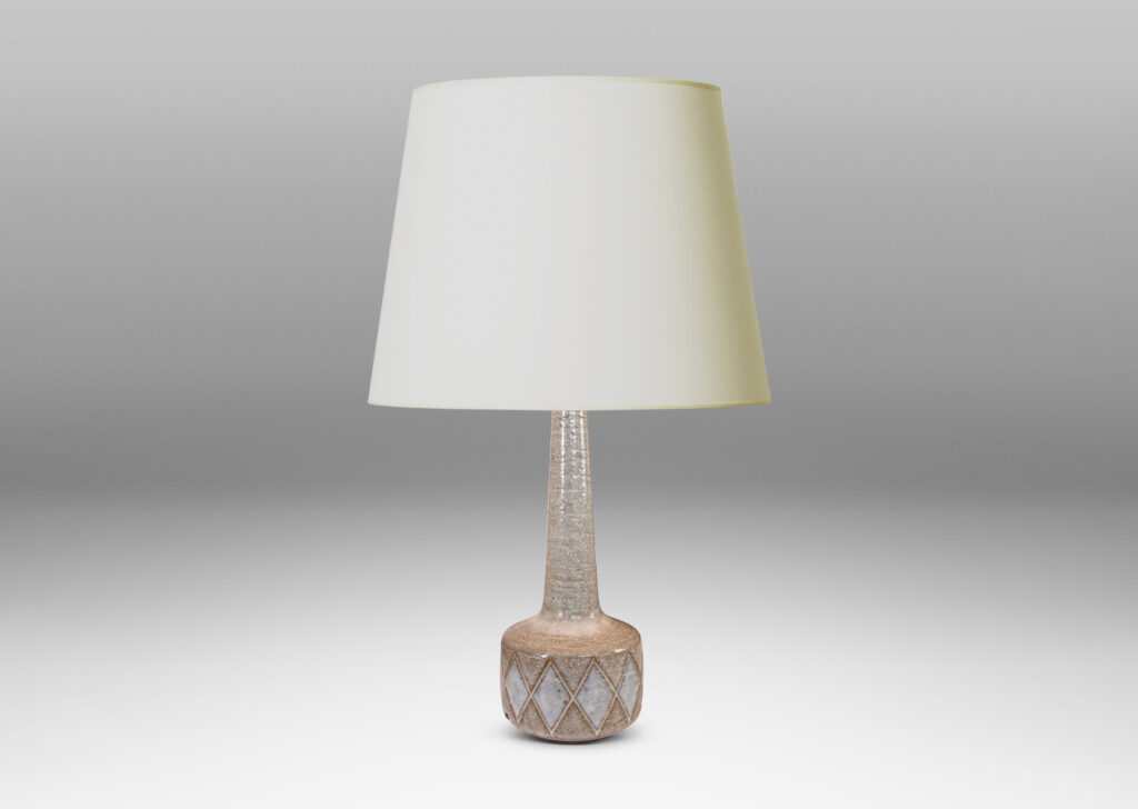 Gallery BAC drum form with carved harlequin design, and tall conical neck, glazed in warm pale gray with some diamond motifs in white