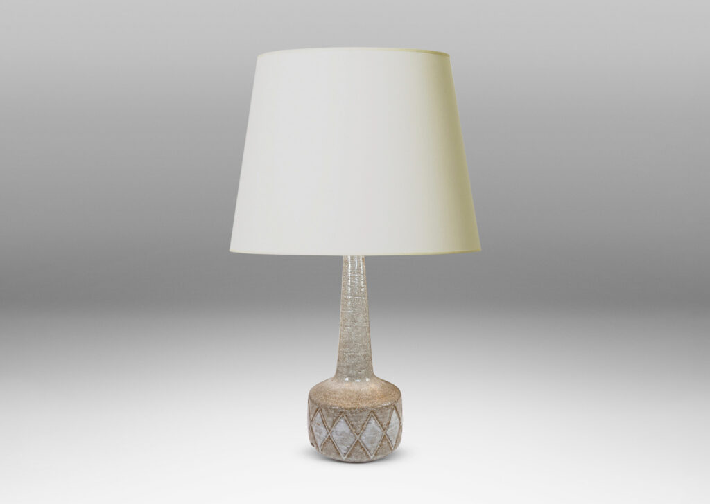 Gallery BAC drum form with carved harlequin design, and tall conical neck, glazed in warm pale gray with some diamond motifs in white