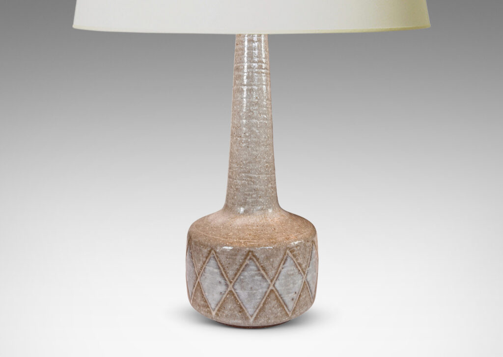 Gallery BAC drum form with carved harlequin design, and tall conical neck, glazed in warm pale gray with some diamond motifs in white