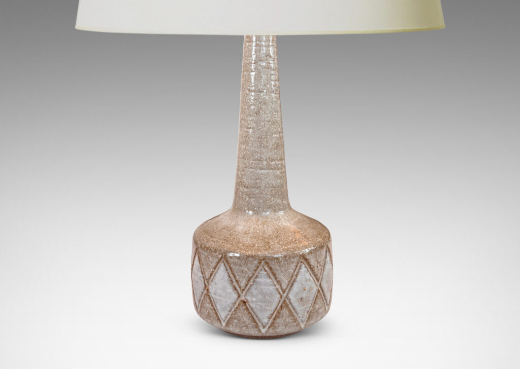 Gallery BAC drum form with carved harlequin design, and tall conical neck, glazed in warm pale gray with some diamond motifs in white