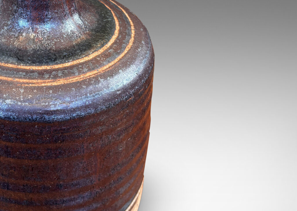 Gallery BAC idged cylindrical form with sprouting neck, partially glazed in a dark brown luster, with sgraffito ring ornament
