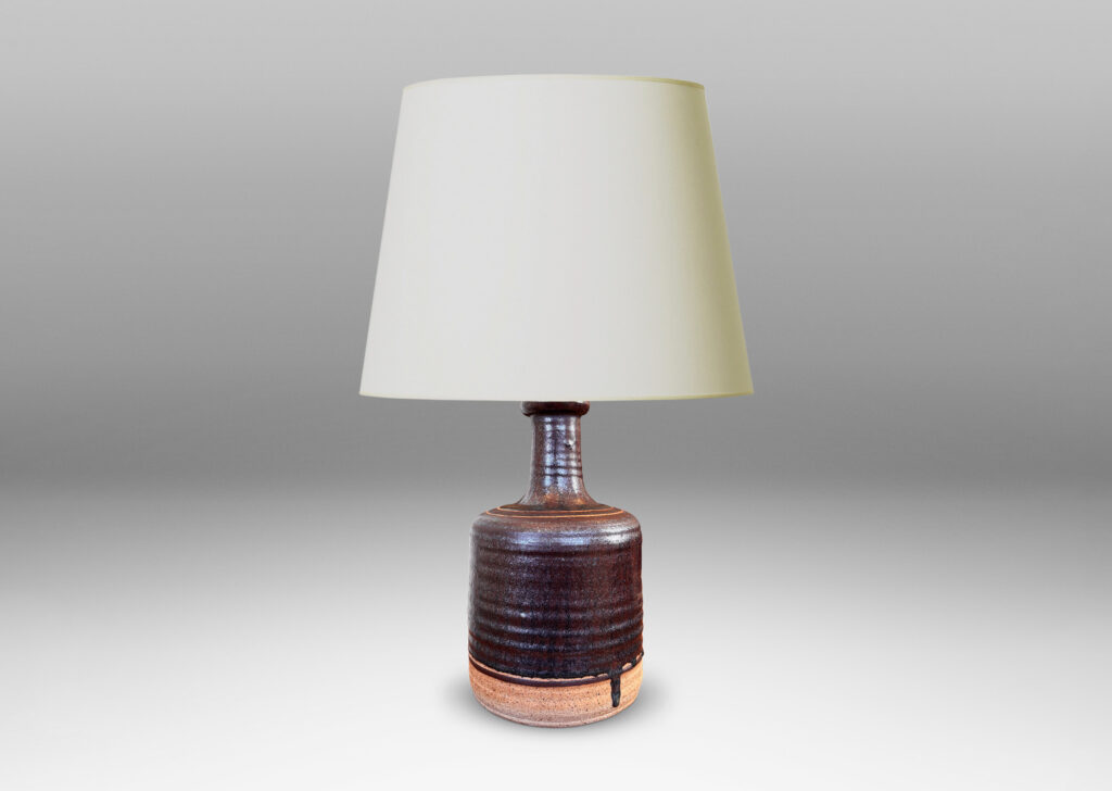 Gallery BAC idged cylindrical form with sprouting neck, partially glazed in a dark brown luster, with sgraffito ring ornament