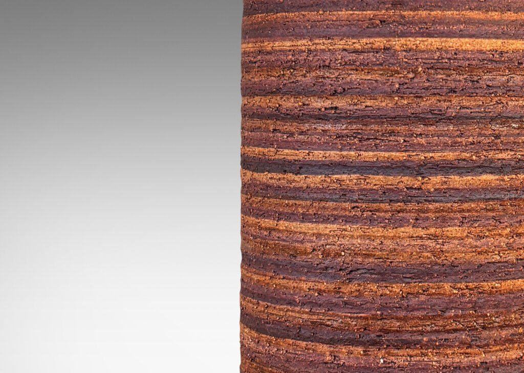 Gallery BAC cylindrical form with rustic grog texture and sprouting neck, partially glazed in matte dark brown