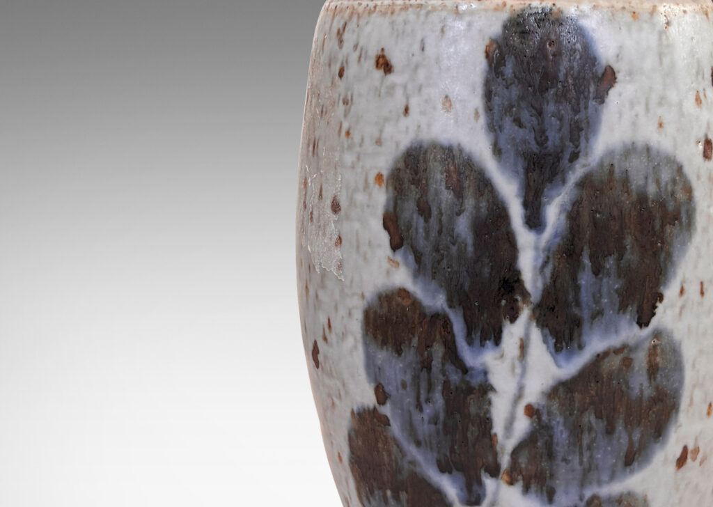 Gallery BAC swelling form and notch articulated neck, glazed in a mottled pale gray, with abstracted foliate forms in dark blue-gray