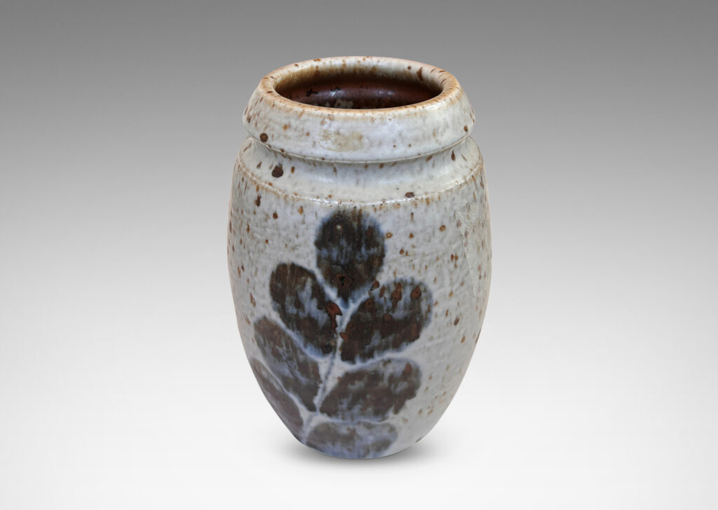 Gallery BAC swelling form and notch articulated neck, glazed in a mottled pale gray, with abstracted foliate forms in dark blue-gray