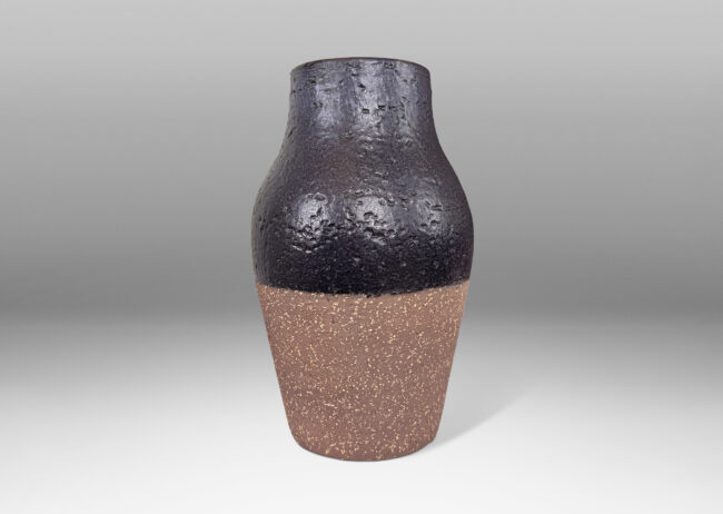 Gallery BAC swelling tapered form with wide mouth, in textured brown grog ceramic, with partial semi-gloss bluish-black glaze