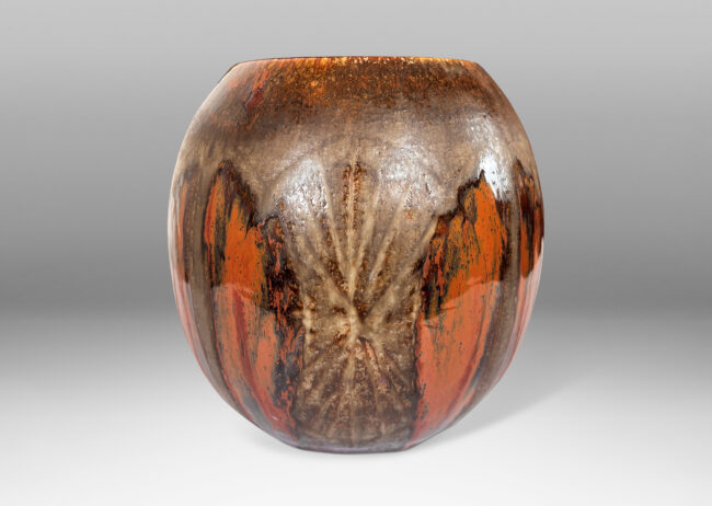 Gallery BAC ovoid form encircled in carved leaf shapes, glazed in red-black luster over matte dark brown