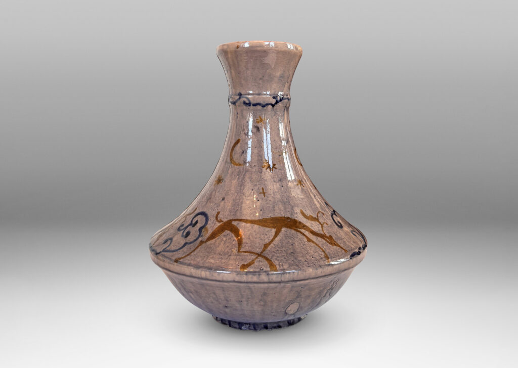 Gallery BAC decanter-like form with tall coved neck, glazed in a thin blue wash over pale rose, overpainted with deer and scrolls in blue and gold