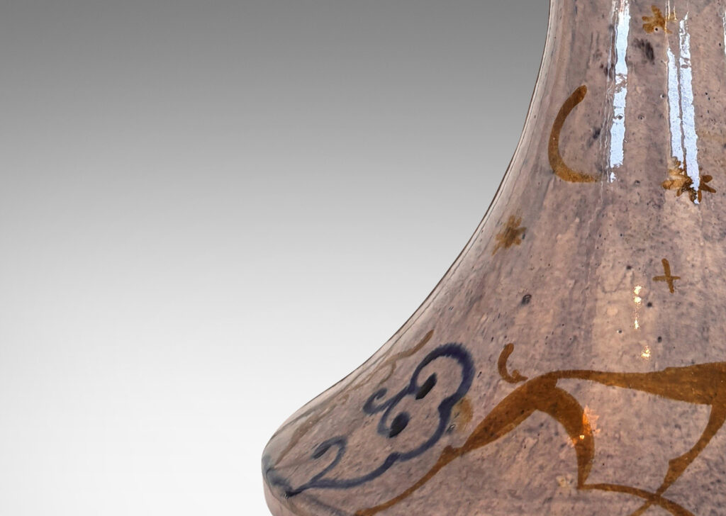 Gallery BAC decanter-like form with tall coved neck, glazed in a thin blue wash over pale rose, overpainted with deer and scrolls in blue and gold