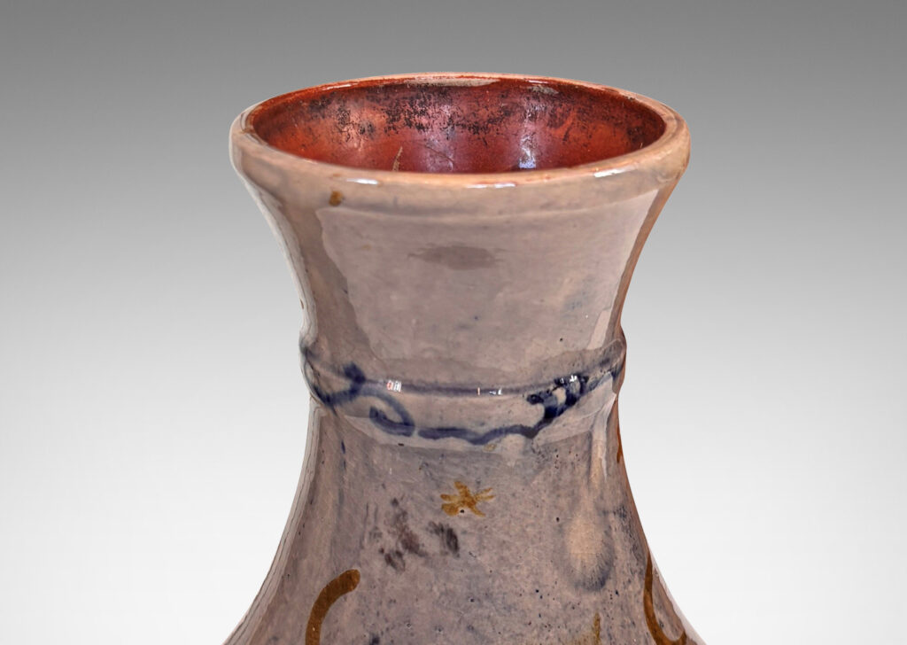 Gallery BAC decanter-like form with tall coved neck, glazed in a thin blue wash over pale rose, overpainted with deer and scrolls in blue and gold