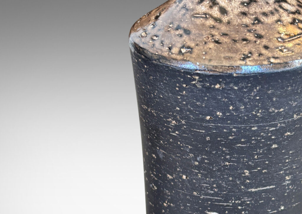 Gallery BAC concave sided cylindrical forms with grog texture and matte brown glaze, with shiny brown caps