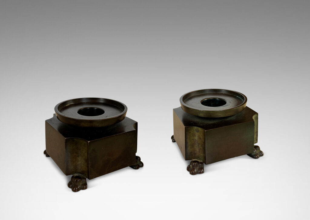 notched square bases, with floating bobèches and lion paw feet