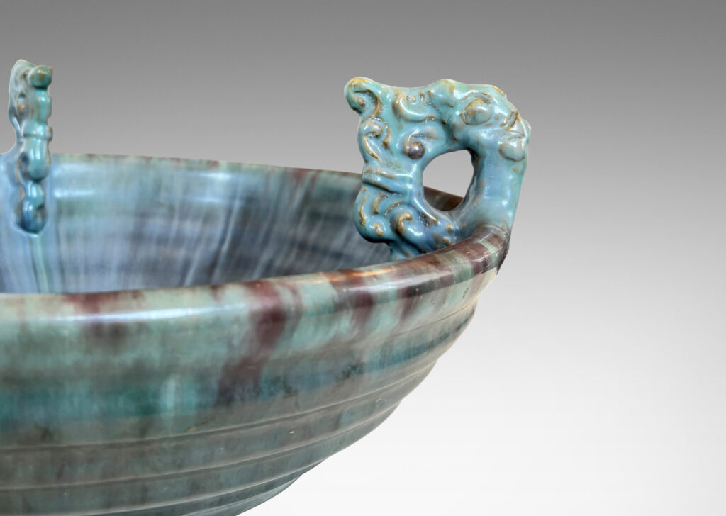 Gallery BAC stepped angled side and three high relief foliate ornaments, glazed in a flowing green