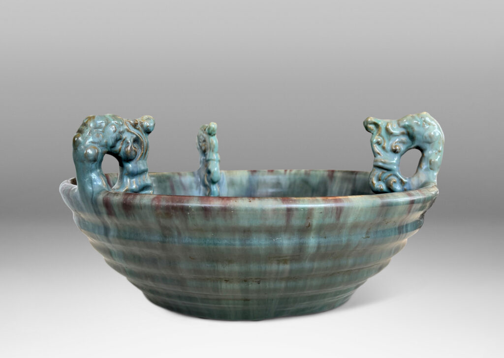 Gallery BAC stepped angled side and three high relief foliate ornaments, glazed in a flowing green