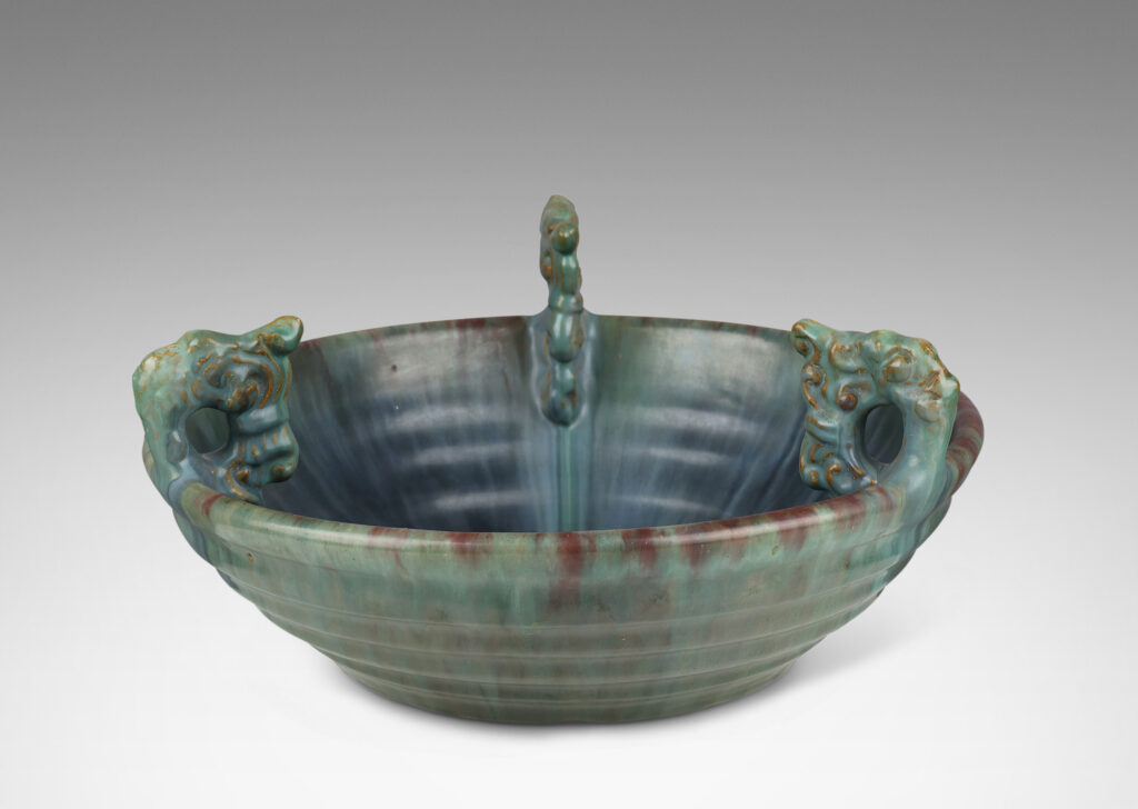 Gallery BAC stepped angled side and three high relief foliate ornaments, glazed in a flowing green