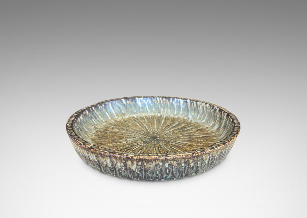 Gallery BAC clean form with angled sides, with carved surface texture and flowing brown glaze
