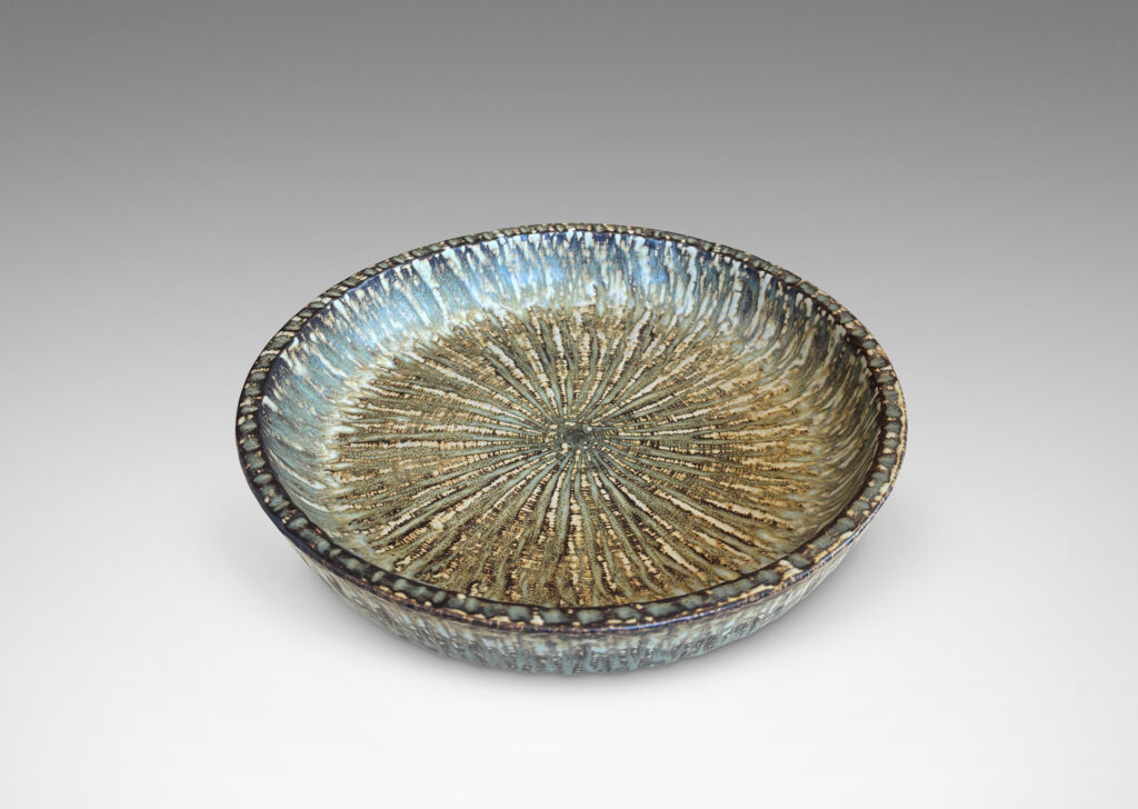 Gallery BAC clean form with angled sides, with carved surface texture and flowing brown glaze