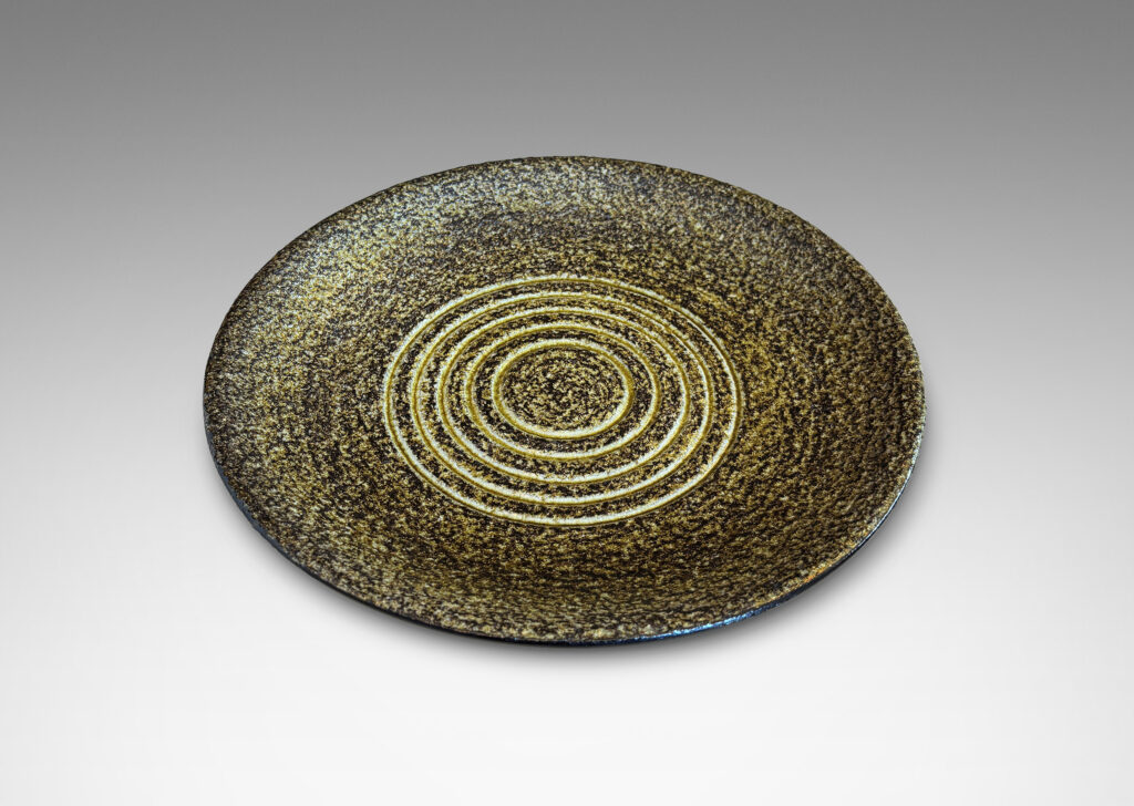 Gallery BAC shallow round form with a rustically textured and concentrically grooved interior glazed in black and green-gray, and a smooth exterior in gloss black