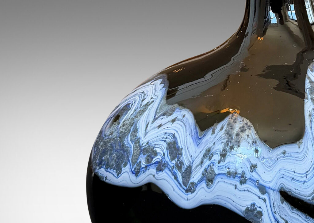 oblong forms with offset sprouting necks, in black with wavy nacreous collar