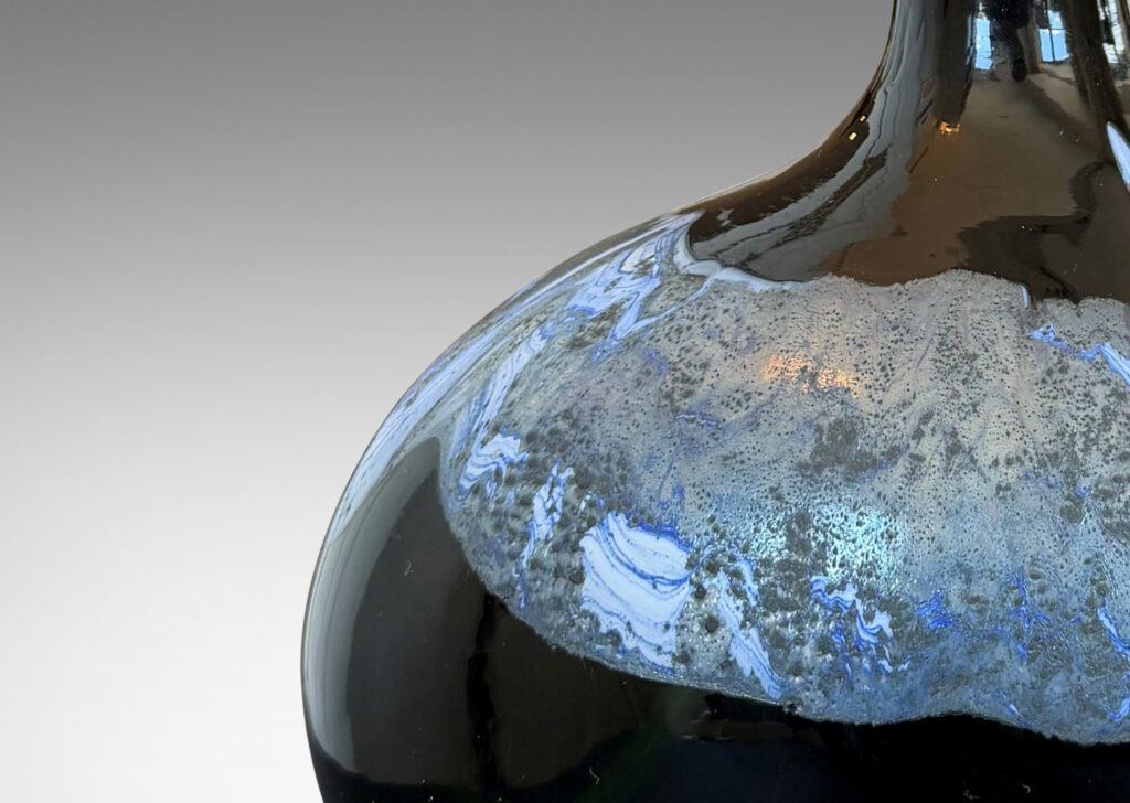 oblong forms with offset sprouting necks, in black with wavy nacreous collar