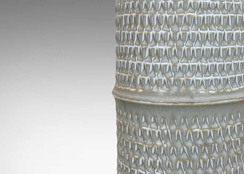 Gallery BAC large cylindrical forms with notched bands and relief rows of triangle motifs, glazed in light warm gray
