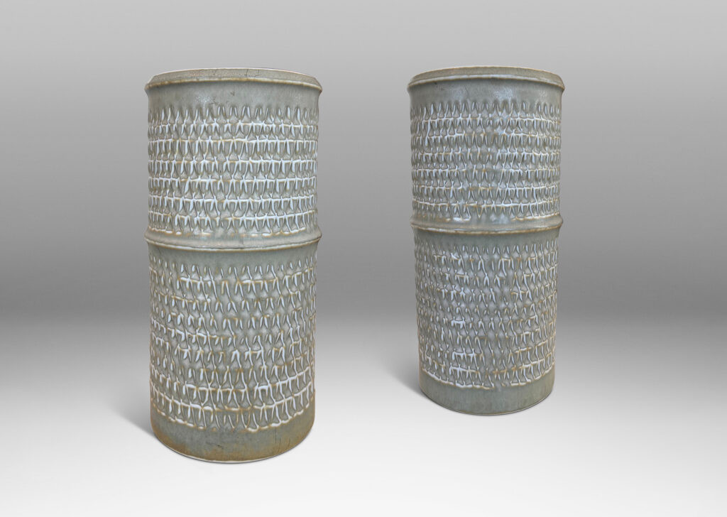 Gallery BAC cylindrical forms with notched bands and lips, and relief rows of triangle motifs, glazed in light warm gray