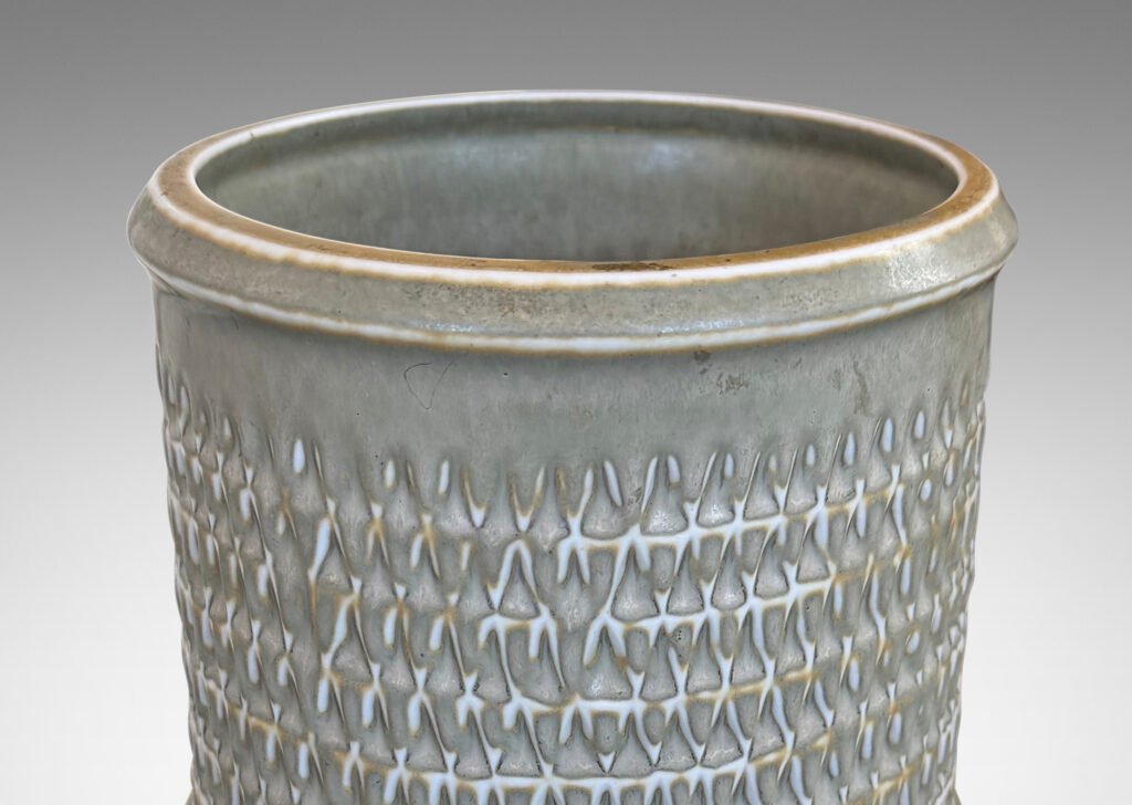 Gallery BAC cylindrical forms with notched bands and lips, and relief rows of triangle motifs, glazed in light warm gray