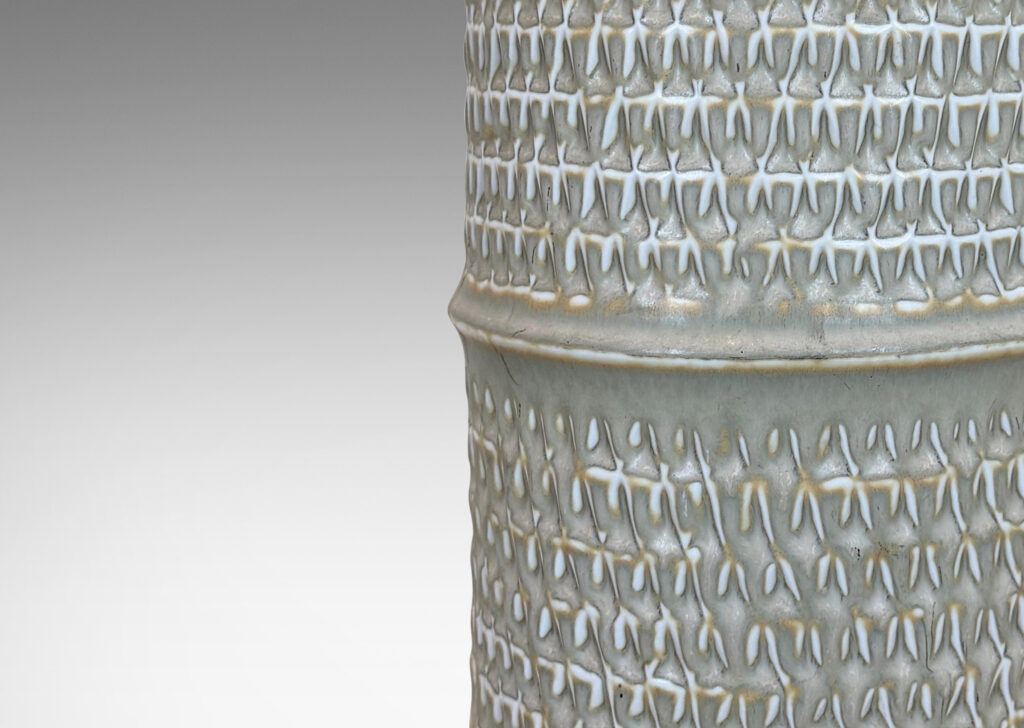 Gallery BAC cylindrical forms with notched bands and lips, and relief rows of triangle motifs, glazed in light warm gray
