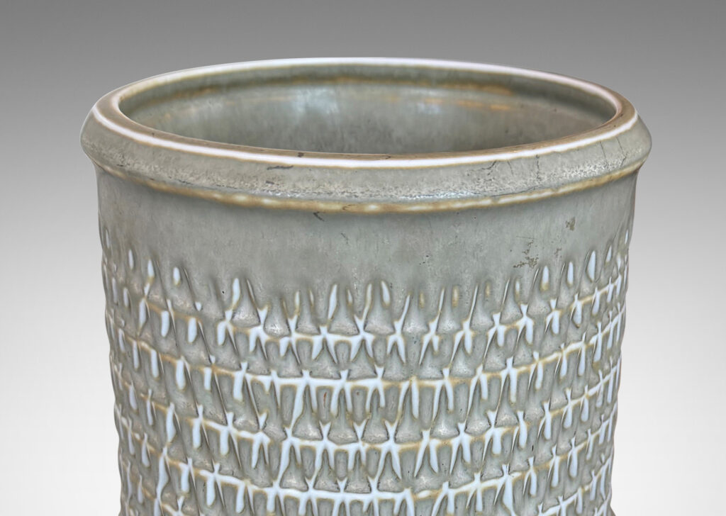 Gallery BAC cylindrical forms with notched bands and lips, and relief rows of triangle motifs, glazed in light warm gray