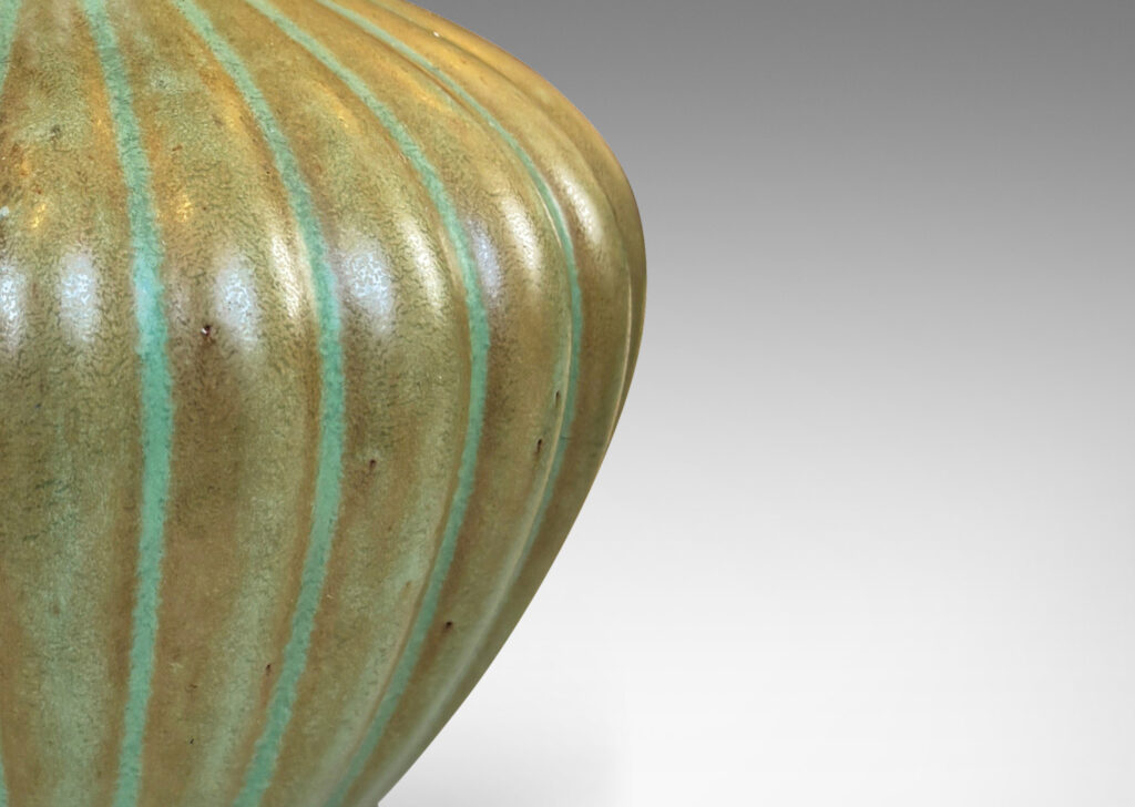 Gallery BAC tapered ribbed form with outstretched neck, glazed in celadon green-brown