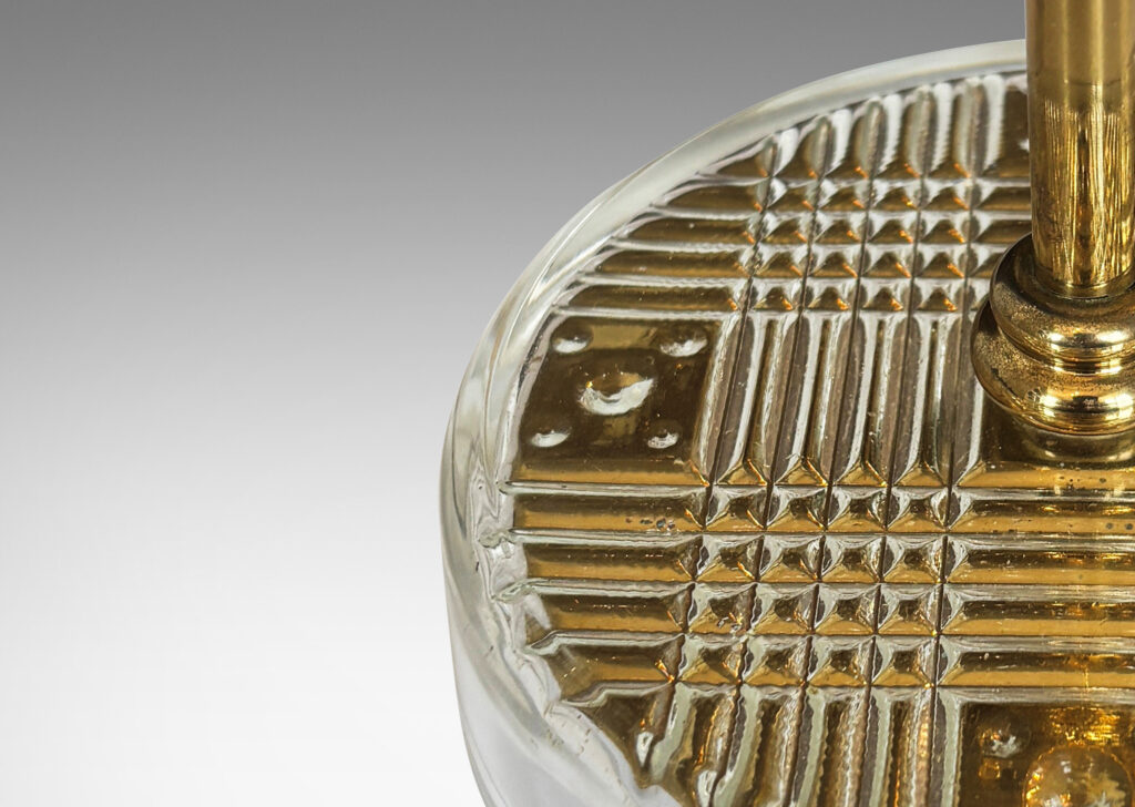 Gallery BAC disk bases in glass with reverse-cut crosshatch pattern, backed by a brass for a shimmering gold effect, with slender brass stands