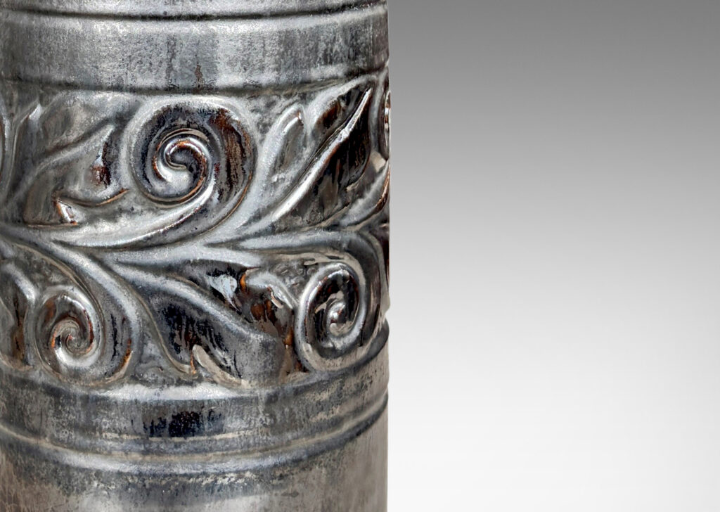Gallery BAC columnar forms with relief bands of folk foliage, glazed in luster brown