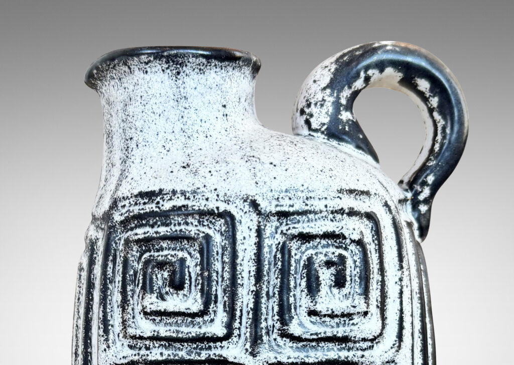 Gallery BAC compressed ovoid form, with spout mouth, loop handle, and Greek key relief design, glazed in white-black