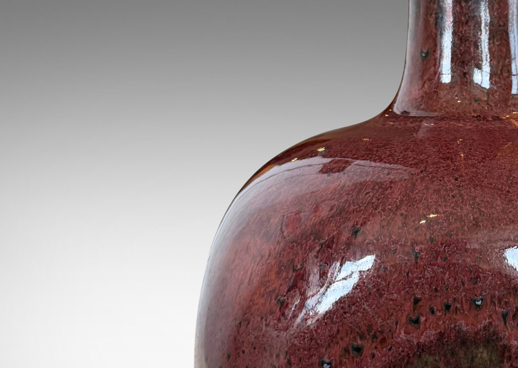 Gallery BAC gourd form, with squared globe body and tall neck, glazed in a deep oxblood burgundy with black accents