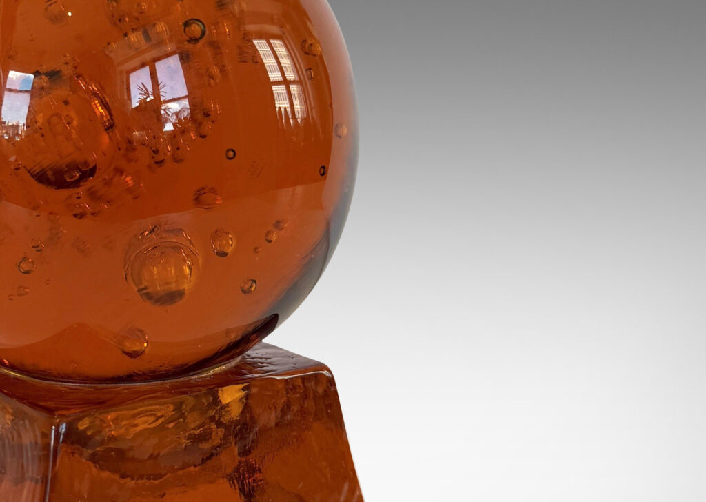 Gallery BAC amber tinted adjustable small globe with encased bubbles resting on a raked square base