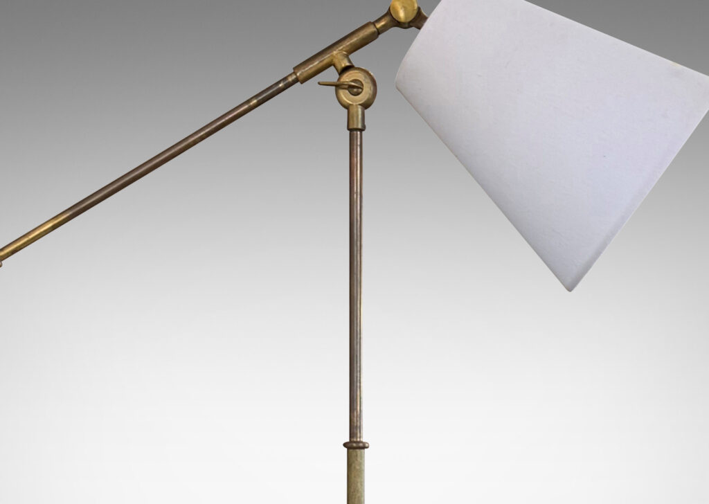 Gallery BAC slender stand on a half-ovoid base, with adjustable directional light; brass and cast iron