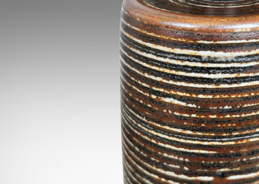Gallery BAC ridged cylindrical forms glazed in a warm brown and pale gray “Sung” glaze, with matte brown angled plinths