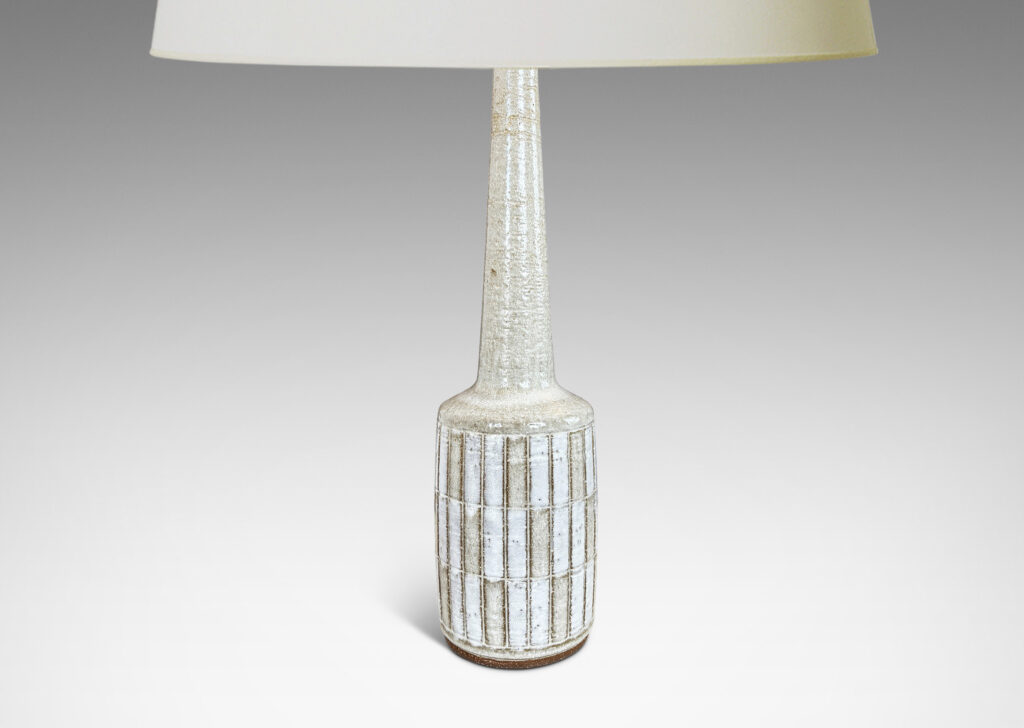 Gallery BAC cylindrical form with carved grid design, and tall conical neck, glazed in pale gray and white