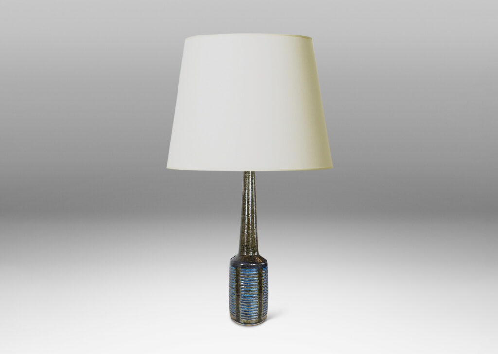 Gallery BAC drum form with vertical bands of carved lines, and tall conical neck, in a grog texture; glazed in gloss dark green with blue