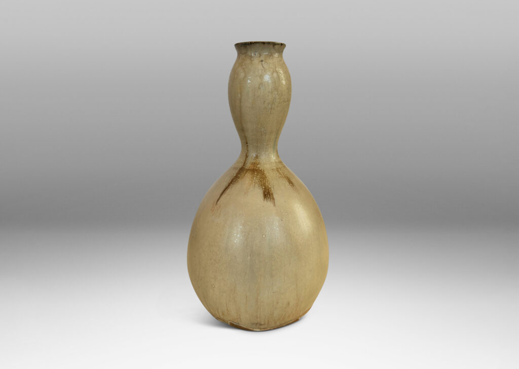 Gallery BAC sinuously modeled double gourd form, glazed in a flowing pale tan with flushes of brown