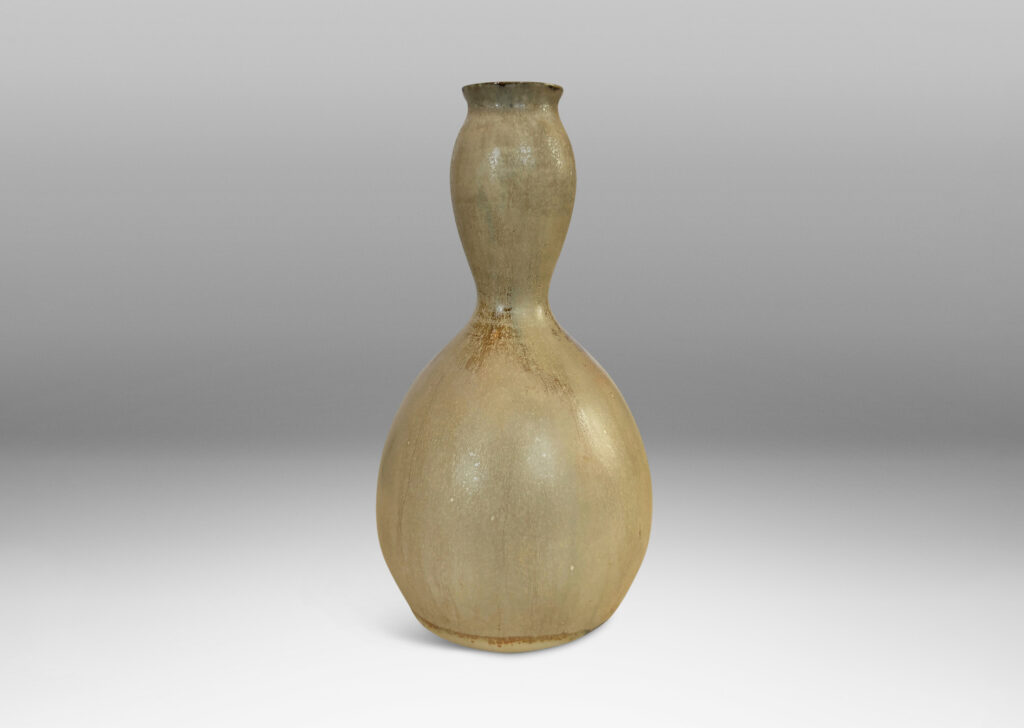 Gallery BAC sinuously modeled double gourd form, glazed in a flowing pale tan with flushes of brown