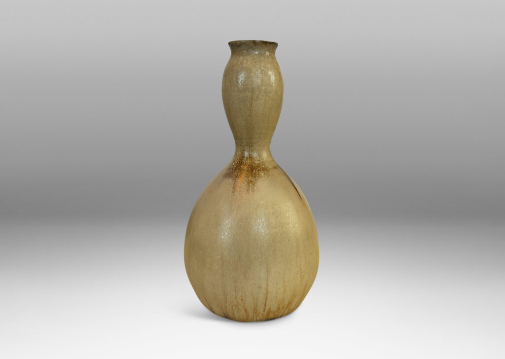 Gallery BAC sinuously modeled double gourd form, glazed in a flowing pale tan with flushes of brown