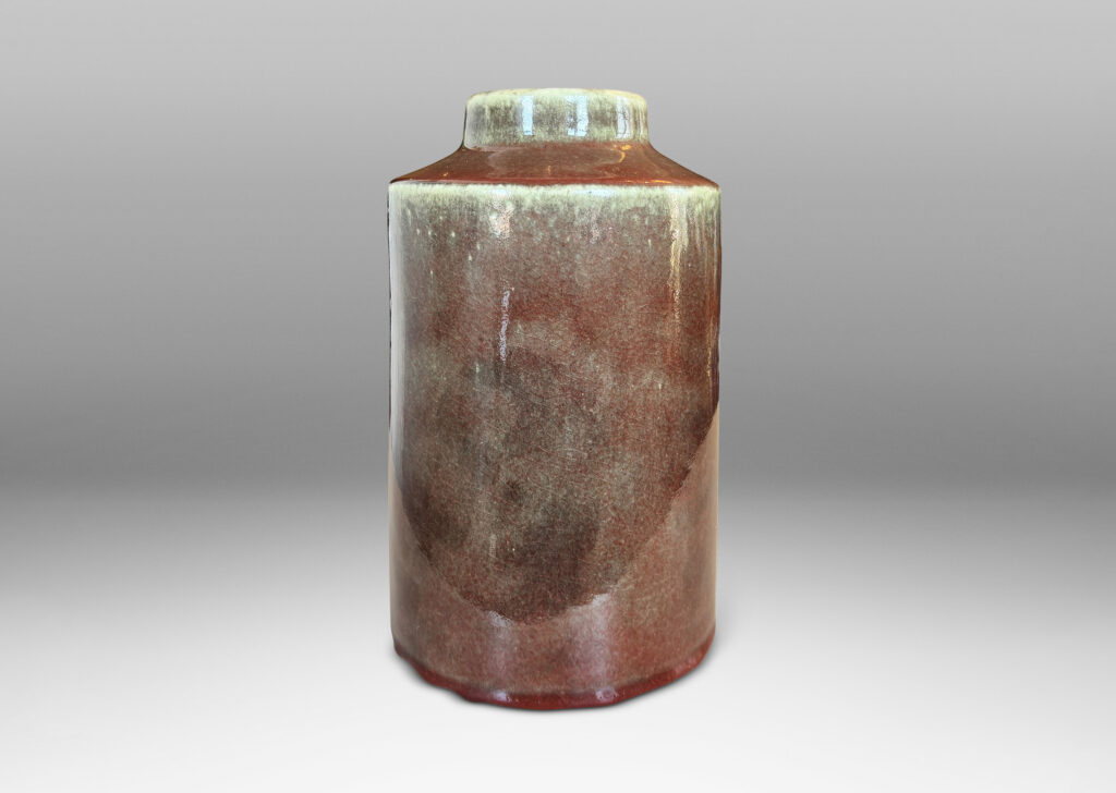 Gallery BAC cylindrical form with angled shoulders and wide mouth, glazed in a shiny oxblood burgundy-celadon green