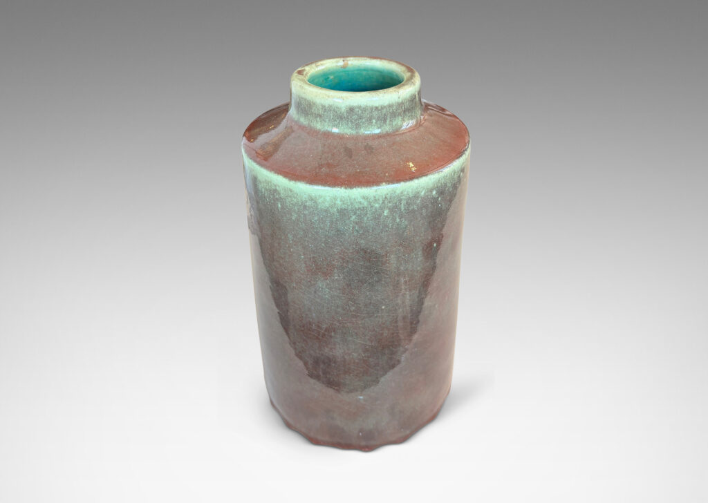 Gallery BAC cylindrical form with angled shoulders and wide mouth, glazed in a shiny oxblood burgundy-celadon green