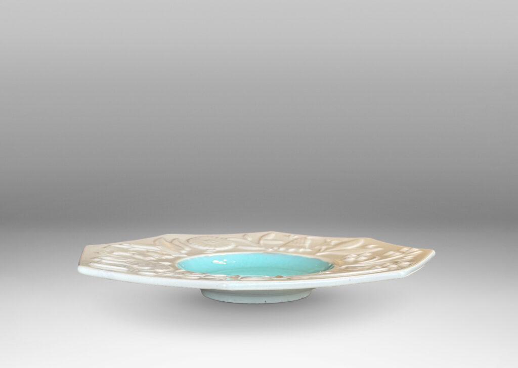 Gallery BAC shallow round center in shiny turquoise, and wide octagonal lip with stylized florals in relief glazed in eggshell finish white
