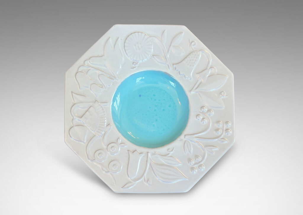 Gallery BAC shallow round center in shiny turquoise, and wide octagonal lip with stylized florals in relief glazed in eggshell finish white