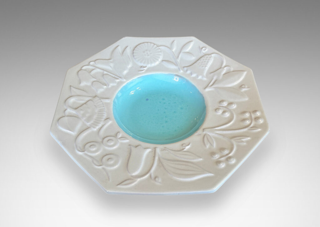 Gallery BAC shallow round center in shiny turquoise, and wide octagonal lip with stylized florals in relief glazed in eggshell finish white