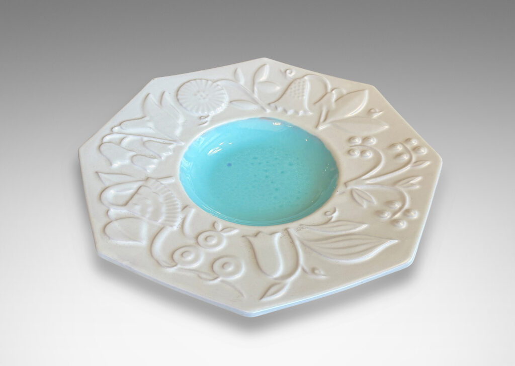 Gallery BAC shallow round center in shiny turquoise, and wide octagonal lip with stylized florals in relief glazed in eggshell finish white
